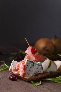 mavi peynir jambon ve ahşap bir masa üzerinde armut ile