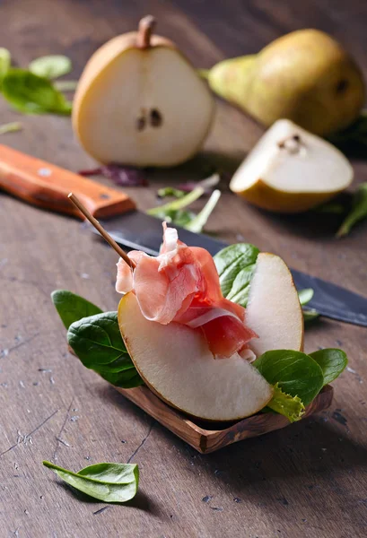 Prosciutto med päron på ett träbord — Stockfoto