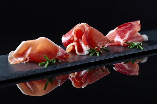 Prosciutto biberiye siyah bir arka plan ile — Stok fotoğraf