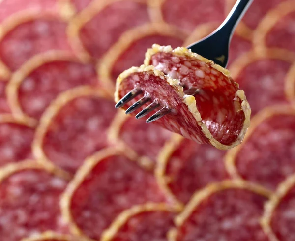 Salami slice on a fork — Stock Photo, Image