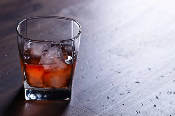 Glass of whiskey with natural ice on a wooden table,copy space f — Stock Photo, Image