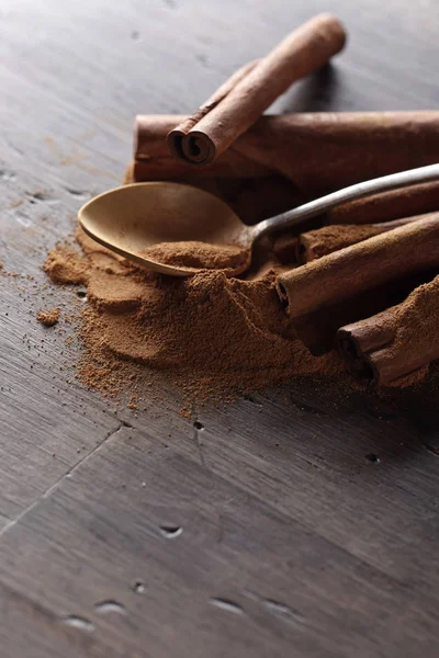 Cinnamon sticks and powder on a wooden table — Stock Photo, Image