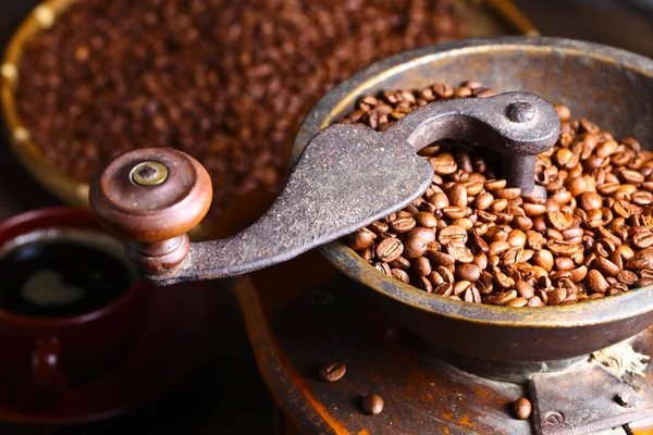 Primer plano de molinillo de café viejo y granos de café tostados — Foto de Stock