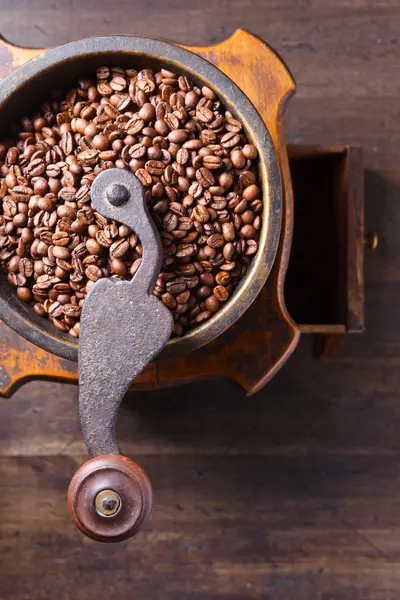 Крупным планом старой кофемолки и жареных кофейных зерен — стоковое фото