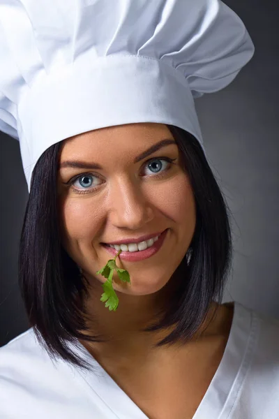 Woman in chef uniform with parsley — Stock Photo, Image