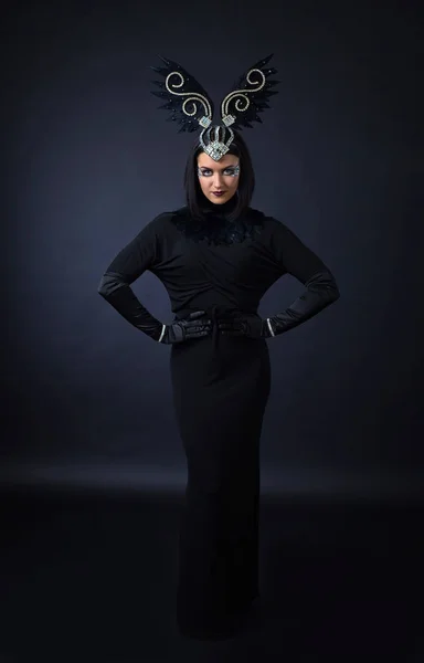 Женщина в костюме черной птицы — стоковое фото