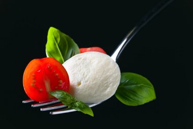  Mozzarella peyniri kiraz domates dilimleri ve yeşil fesleğen ile 