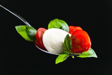  Mozzarella peyniri kiraz domates dilimleri ve yeşil fesleğen ile 