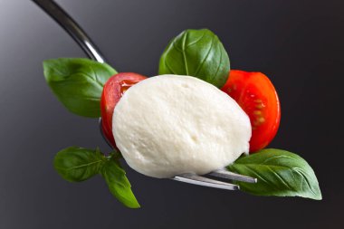  Mozzarella peyniri kiraz domates dilimleri ve yeşil fesleğen ile 