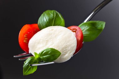  Mozzarella peyniri kiraz domates dilimleri ve yeşil fesleğen ile 