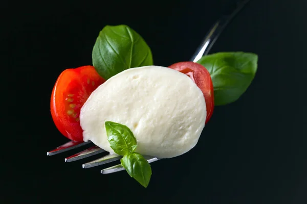 Mozzarella cheese with tomato cherry slices and green basil — Stock Photo, Image
