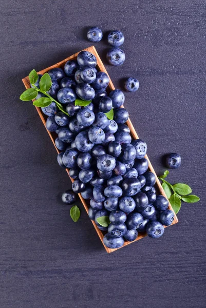 与上一个黑色的桌子的绿枝新鲜蓝莓 — 图库照片