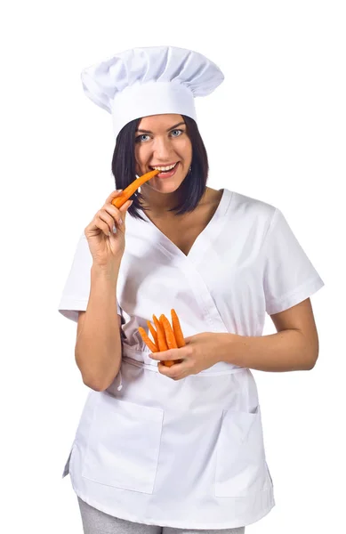 Skönhet brunett kvinna i kock uniform med morot på vit — Stockfoto
