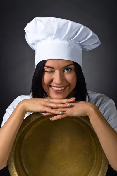 Краса Брюнетка Жінка в кулінарній формі з великою мідною сковородою  . — стокове фото