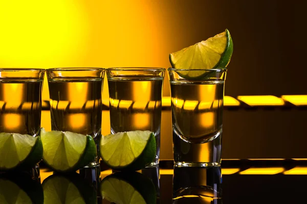 Tequila messicana in oro in bicchieri corti con calce — Foto Stock