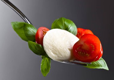  Mozzarella peyniri kiraz domates dilimleri ve yeşil fesleğen ile 