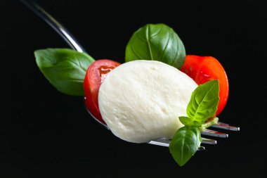  Mozzarella peyniri kiraz domates dilimleri ve yeşil fesleğen ile 