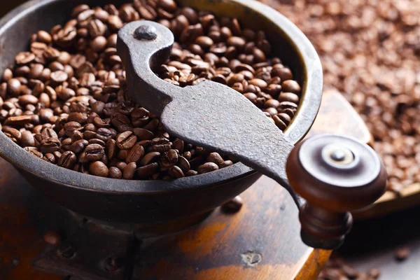 Nahaufnahme alter Kaffeemühle und gerösteter Kaffeebohnen — Stockfoto