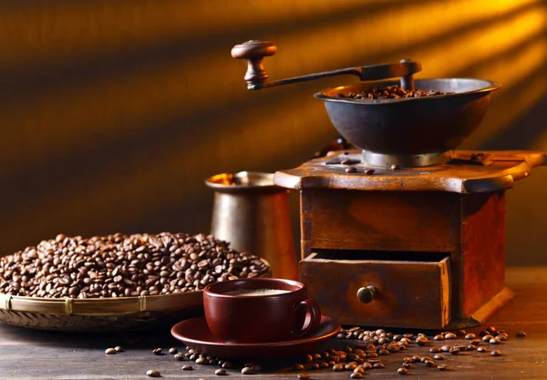 Старая деревянная кофемолка и жареная кофейная зёрна — стоковое фото
