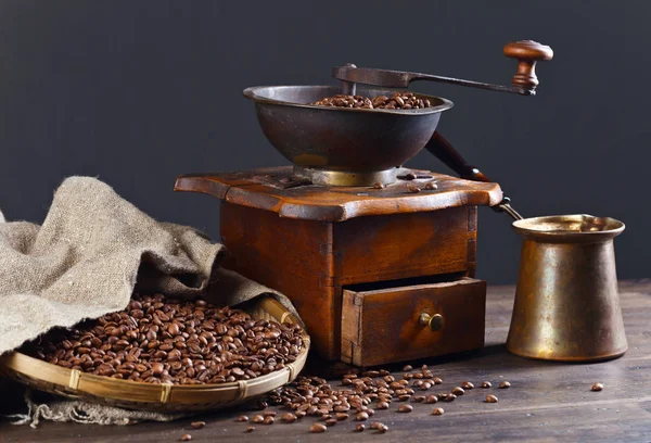 Molinillo de café viejo y granos de café tostados en mesa de madera — Foto de Stock