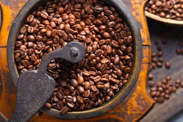 Primer plano de molinillo de café viejo y granos de café tostados — Foto de Stock