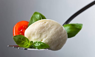  Mozzarella peyniri kiraz domates dilimleri ve yeşil fesleğen ile 