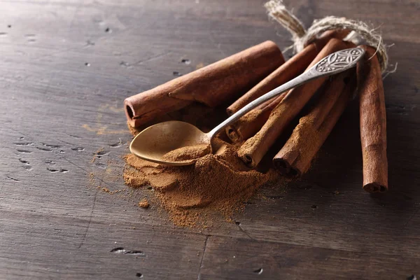 Cinnamon sticks and powder on a wooden table — Stock Photo, Image