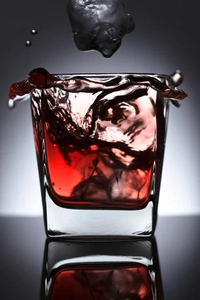 Bicchiere di whisky con ghiaccio cadente su fondo nero — Foto Stock