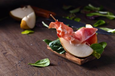 Prosciutto ile armut ahşap bir masa üzerinde