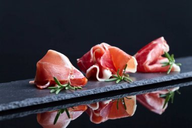 Prosciutto biberiye siyah bir arka plan ile