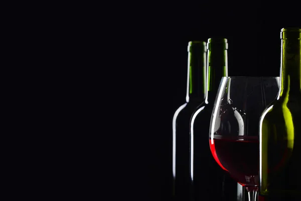 ボトルと黒地に赤ワインのガラス . — ストック写真