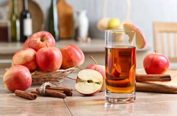 Glas äppeljuice och mogna rosa äpplen på ett köksbord — Stockfoto