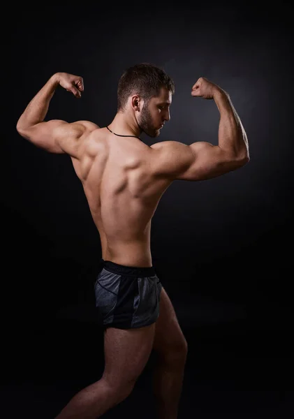 Jeune bodybuilder sur fond noir — Photo