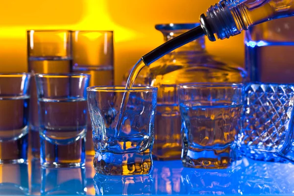 Очки с алкогольными напитками на стеклянном столе в баре — стоковое фото