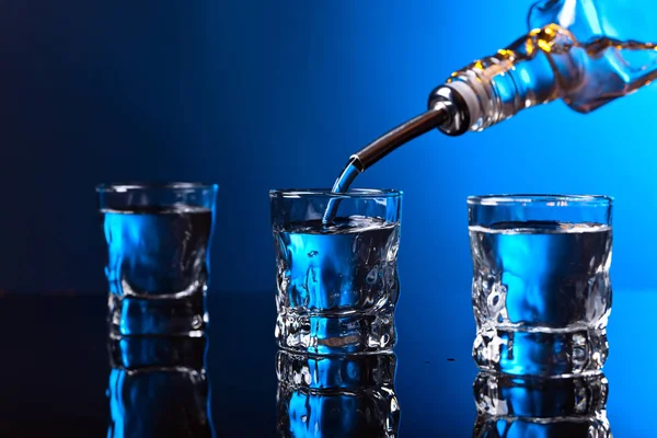 Vodka dans le bar sur un fond bleu — Photo