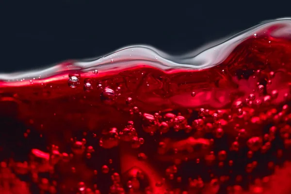Abstrakta stänk av rött vin på en svart bakgrund — Stockfoto