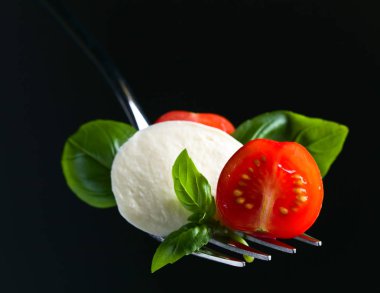 Mozzarella peyniri kiraz domates dilimleri ve yeşil fesleğen ile 
