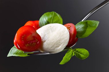  Mozzarella peyniri kiraz domates dilimleri ve yeşil fesleğen ile 
