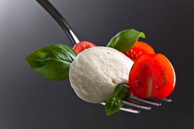  Mozzarella peyniri kiraz domates dilimleri ve yeşil fesleğen ile 