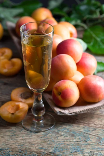 Сочные абрикосы с листьями и бокалом сладкого вина  . — стоковое фото