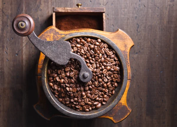 Nahaufnahme alter Kaffeemühle und gerösteter Kaffeebohnen — Stockfoto