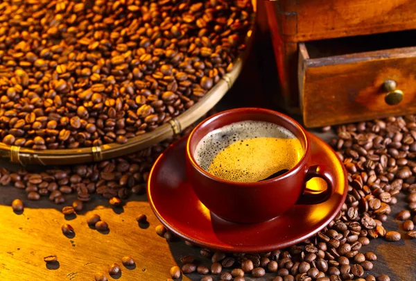 Kubek czarnej kawy, młynek do kawy i palonych ziaren — Zdjęcie stockowe