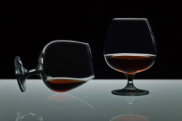 Two snifters of brandy on glass table — Stock Photo, Image