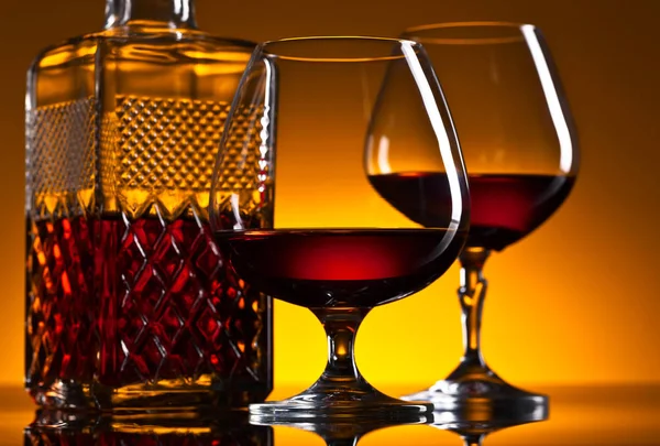 Glasses of brandy on the reflective background — Stock Photo, Image