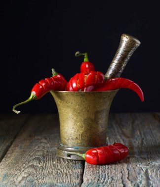 Eski bakır harç içinde kırmızı biber biber.