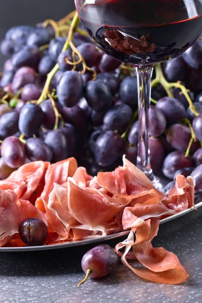 Prosciutto with grape and red wine . — Stock Photo, Image