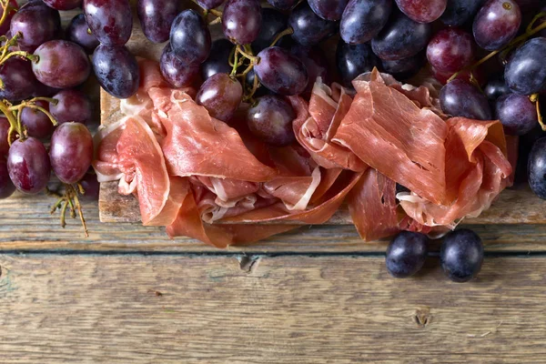 Prosciutto with blue grape . — Stock Photo, Image