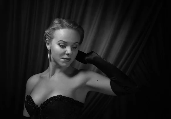 Young beautiful woman in black with pearl earrings.