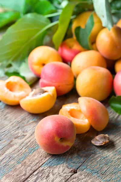 Sappige verse abrikozen met bladeren op oude houten tafel . — Stockfoto