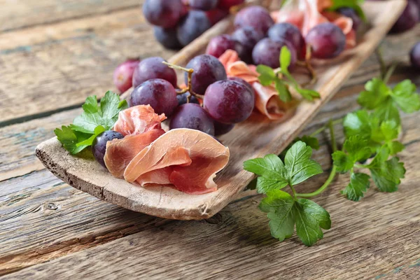 Jamon serrano with parsley and grape. — Stock Photo, Image